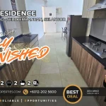 Modern kitchen featuring dark stone counter tops, gas cooktop, double sink, and built-in cabinets in a fully furnished 2-bedroom unit at O2 Residence Seri Kembangan.